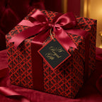 Elegant red and black fleur-de-lis luxury gift wrap with a satin ribbon bow by Wrapped Studios.
