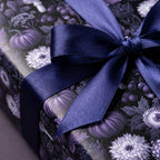 Gothic purple floral wrapping paper with pumpkins and a navy satin ribbon bow by Wrapped Studios.