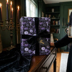 Moody gothic Halloween wrapping paper with purple pumpkins and black velvet ribbon by Wrapped Studios.