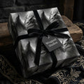 Gothic dragon wrapping paper with a black velvet bow on a gift box by Wrapped Studios.