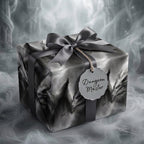 Gothic dragon wrapping paper with grey ribbon and a Dungeon Master tag on a gift box by Wrapped Studios.