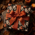 Gothic skull and pumpkin Halloween gift wrap with a rust orange ribbon by Wrapped Studios.