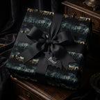 Elegant Halloween gift wrapped in spooky cityscape wrapping paper with black ribbon and bat tag that says "Boo!"