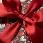 Valentine's Day wrapping paper with red hearts and a luxury satin bow, romantic gift wrap by Wrapped Studios.