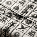 Gothic wrapping paper with vintage skulls and roses tied with black twine bow by Wrapped Studios.