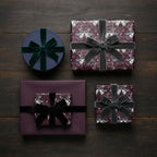 Elegant gift wrapping: purple moth pattern paper, velvet ribbon, for luxury birthday or holiday presents.