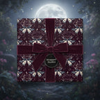 Elegant gift wrapped in luxury moth and moon wrapping paper with a velvet burgundy ribbon.