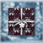 Square gift wrapped in dark floral wrapping paper with moths, moon, and silver ribbon.