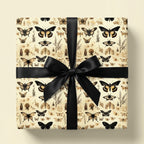 Gift box in elegant vintage butterfly wrapping paper with a black satin bow.