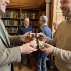 Man exchanging a gift wrapped in butterfly pattern paper with brown ribbon.