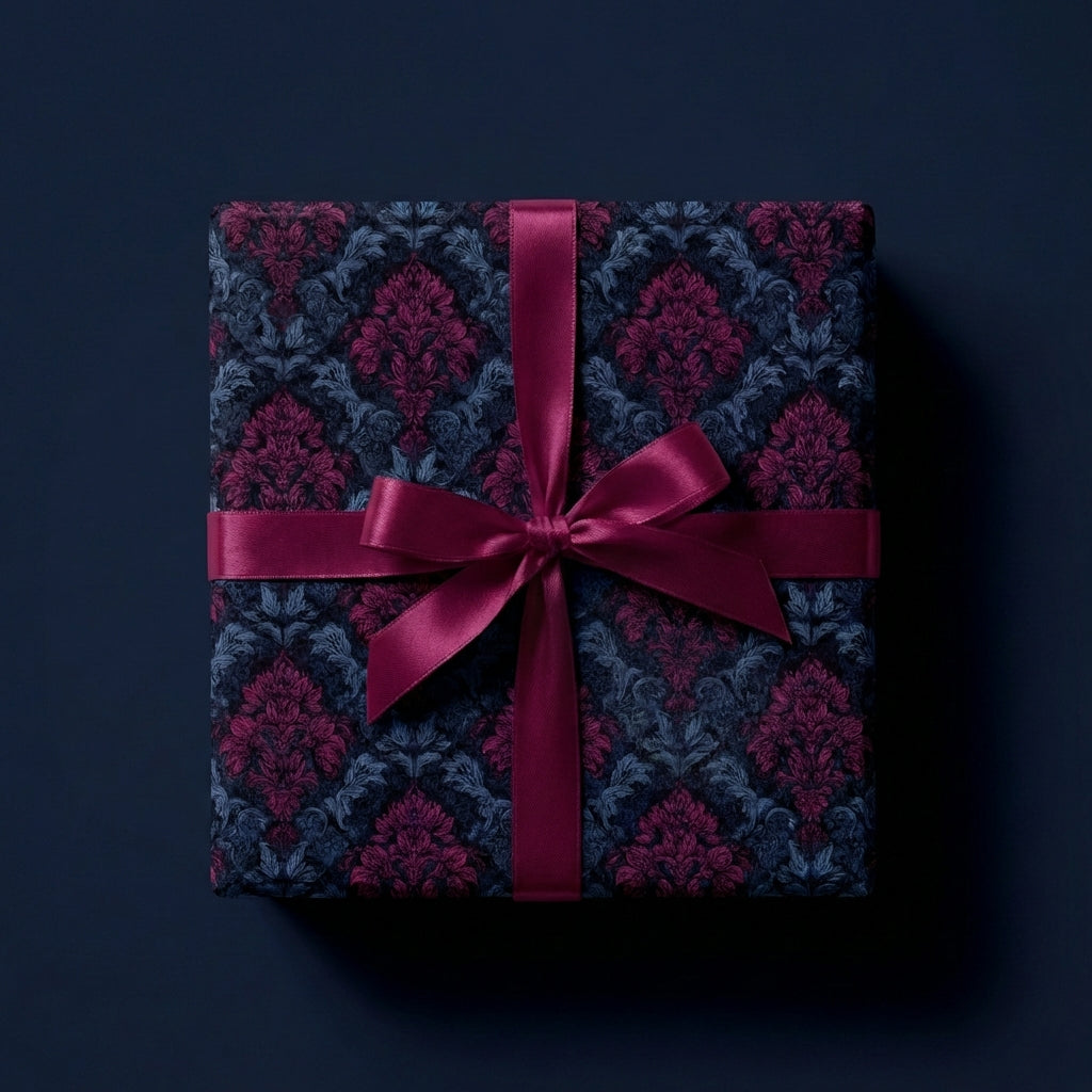 Elegant square gift box with luxury floral wrapping paper and wine-colored satin ribbon.
