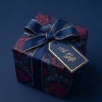 Elegant gift wrapped in navy floral wrapping paper with gold-trimmed ribbon and tag, perfect for birthdays.