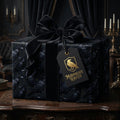 Gothic raven wrapping paper with a black velvet bow on a luxury gift box by Wrapped Studios.