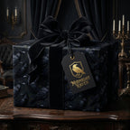 Gothic raven wrapping paper with a black velvet bow on a luxury gift box by Wrapped Studios.