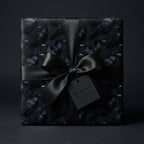 Gothic raven wrapping paper with a black satin bow, luxury Halloween gift wrap by Wrapped Studios.