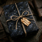 Gothic raven wrapping paper by Wrapped Studios on a gift box tied with rustic twine.