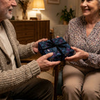 Elderly couple exchanging a gift wrapped in luxury floral paper with a black ribbon from Wrapped Studios.