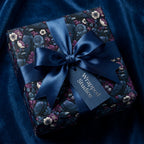 Luxury gift box with dark floral raven wrapping paper and navy satin ribbon by Wrapped Studios.