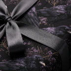 Gothic raven wrapping paper with grey satin ribbon. Moody crow and dark floral gift wrap by Wrapped Studios.
