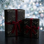 Gothic raven luxury gift wrap with red velvet bows on holiday gifts by Wrapped Studios.