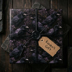 Gothic raven wrapping paper by Wrapped Studios on a gift box with black twine and a wax seal.