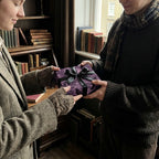 Present exchange with luxury gift wrap: dark purple paper with a raven pattern and black satin ribbon.