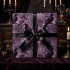 Elegant gift wrapped in raven print wrapping paper with a satin black bow against a dark, moody backdrop.