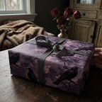 Raven-themed gift wrapped in purple floral wrapping paper with gray ribbon.