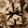 Elegant crow-themed wrapping paper with a brown velvet ribbon, ideal for a unique gift presentation from Wrapped Studios.