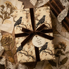 Elegant crow-themed wrapping paper with a brown velvet ribbon, ideal for a unique gift presentation from Wrapped Studios.