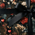 Luxury dark floral wrapping paper with red hearts and a black satin bow by Wrapped Studios.
