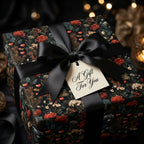 Luxury dark floral wrapping paper with red roses, black satin bow, and gift tag by Wrapped Studios.