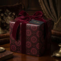 Luxury burgundy gothic gift wrap with a velvet ribbon on a holiday present by Wrapped Studios.