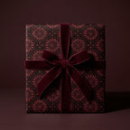 Luxury burgundy gift wrap featuring a vintage gothic pattern and matching velvet bow by Wrapped Studios.