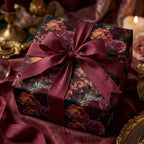 Luxury burgundy and gold floral wrapping paper with a matching ribbon on a gift box by Wrapped Studios.