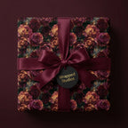 Luxury burgundy floral wrapping paper with gold roses and satin bow, by Wrapped Studios.