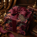 Luxury floral wrapping paper in moody burgundy roses with a ribbon bow and tag by Wrapped Studios.