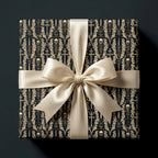Spooky gothic skull gift wrap in black and gold with a cream satin bow by Wrapped Studios.
