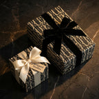 Gothic skull wrapping paper on elegant Halloween gift boxes with velvet and satin ribbons by Wrapped Studios.