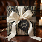 Gothic wrapping paper with skulls and crosses, tied with a cream satin bow by Wrapped Studios.