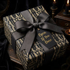 Black and gold gothic wrapping paper with skulls, black ribbon, and 'Open If You Dare' tag by Wrapped Studios.