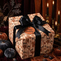 Gothic skull Halloween wrapping paper with a luxury black satin bow by Wrapped Studios.