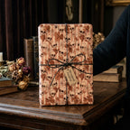 Gothic skull Halloween wrapping paper with black twine bow and Wrapped Studios tag.
