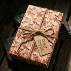 Gothic skull wrapping paper with a twine bow on a rustic gift by Wrapped Studios.