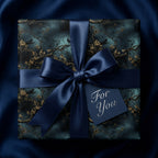 Elegant gift wrapped in dark floral wrapping paper with a navy ribbon and "For You" tag.