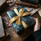 Wrapped Studios elegant gift box with gold ribbon and moody floral wrapping paper.