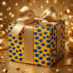 Graduation cap wrapping paper in yellow and blue with a gold bow by Wrapped Studios.
