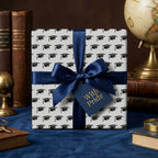 Graduation wrapping paper with black mortarboard caps and navy blue ribbon by Wrapped Studios.