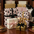 Pink graduation cat wrapping paper featuring tuxedo cats in caps and bows, by Wrapped Studios.