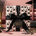 Pink graduation wrapping paper featuring cute tuxedo cats in graduation caps, by Wrapped Studios.